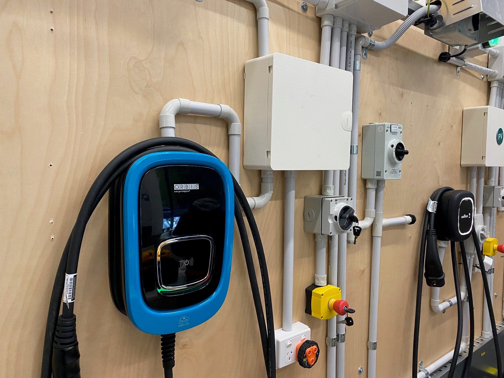 Wall of EV chargers including an Orbis Viaris and a Wallbox unit