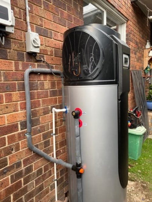 Heat pump hot water system installed against a brick wall Heat pump hot water system installed against a brick wall